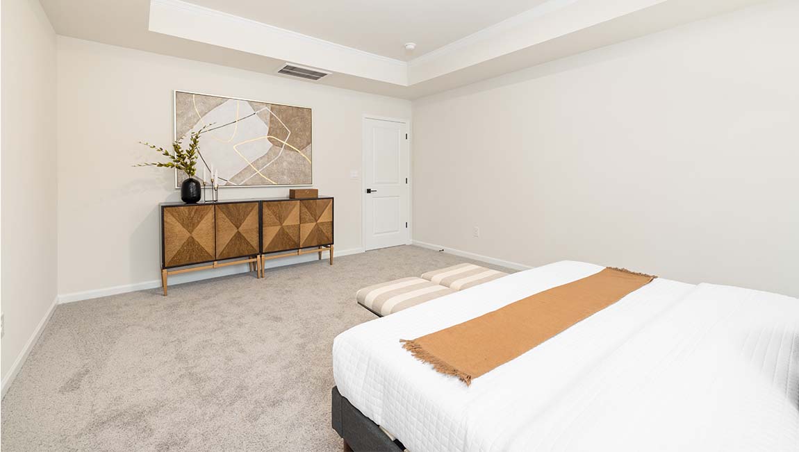 Primary bedroom with carpet and large windows