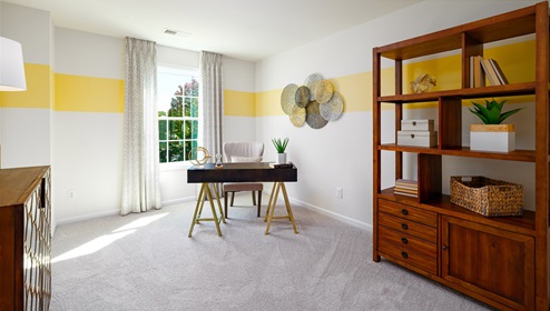 Carpeted bedroom with medium window, being used as an office