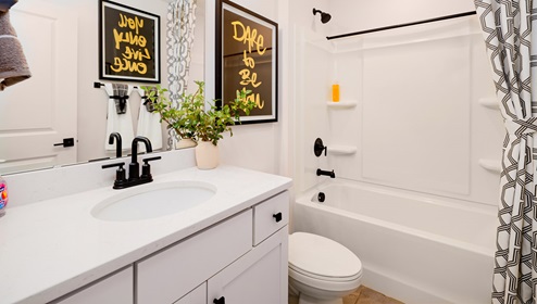 Bathroom with white counters, and cabinets and bathtub
