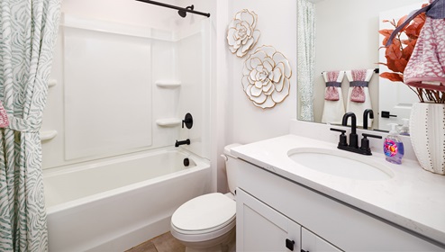 Bathroom with white counters, and cabinets and bathtub