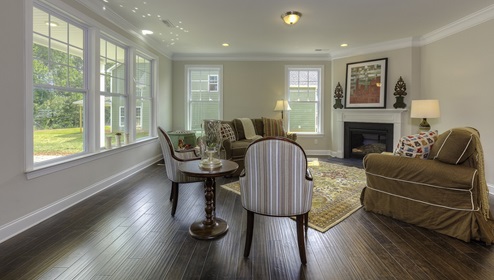 Family room with wood floors, fireplace and many large windows