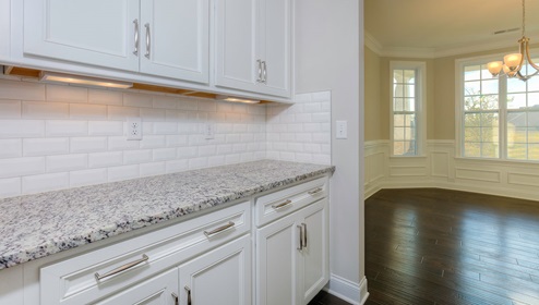 Butlers pantry with white cabinets and white subway tile backsplash