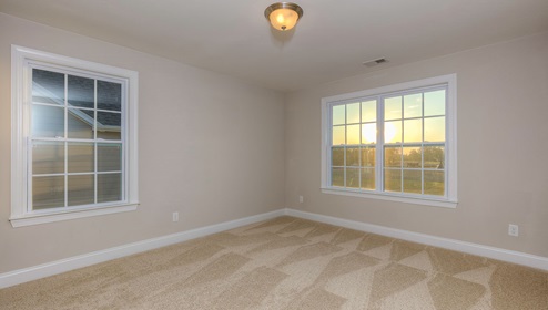 Carpeted bedroom with two large windows