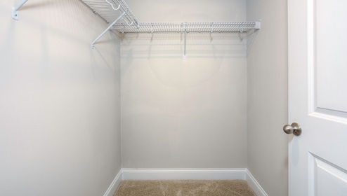 Carpeted walk in closet with racks for hanging