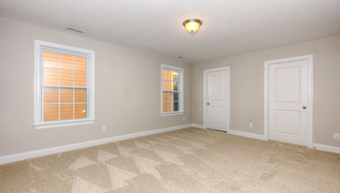 Carpeted bedroom with large windows