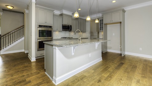 Kitchen and island with white cabinets, subway tile backsplash and stainless steel appliances