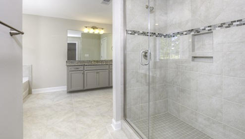 Primary bathroom with bathtub and glass door shower combination