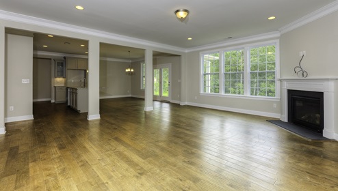 Family room with fireplace, large windows and view of kitchen