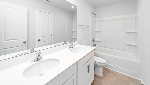 Bathroom with bathtub, white counters and cabinets