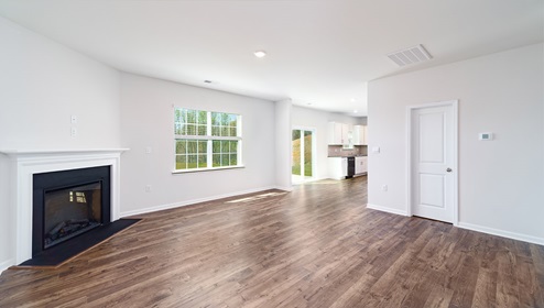 Family room with fireplace, wood floors, and large window, breakfast areain view