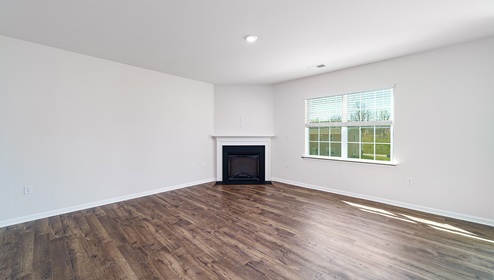 Family room with fireplace, wood floors, and large window