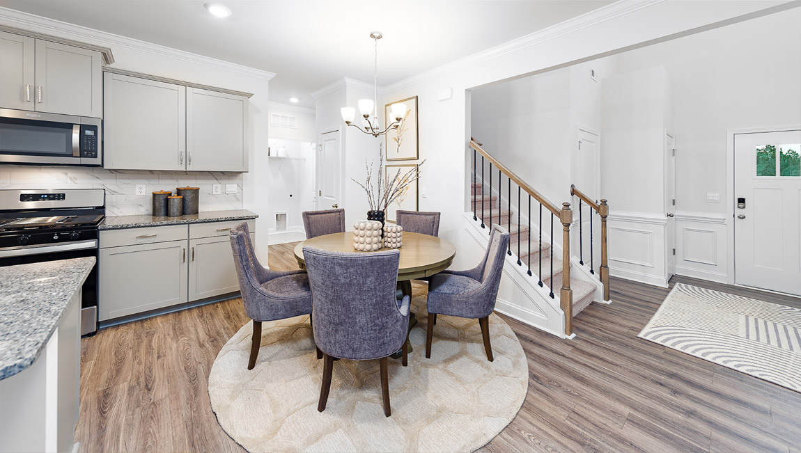 Dining area beside kitchen with wood floors