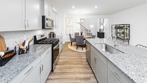 Kitchen and island with white cabinets and stainless steel appliances