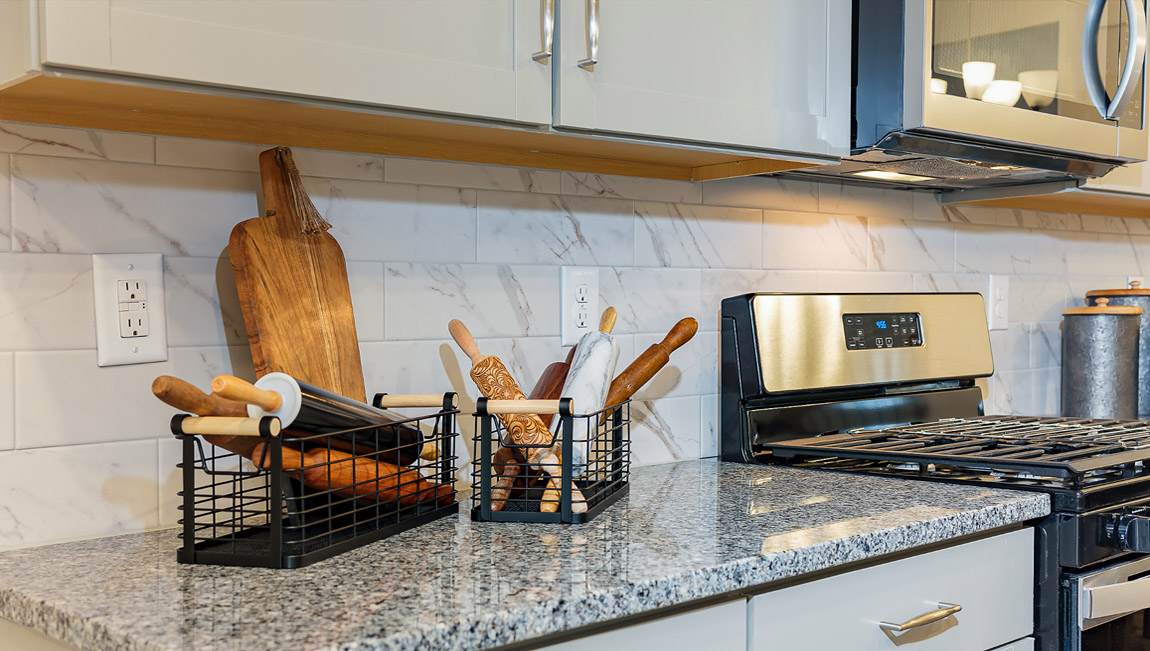 Kitchen and island with white cabinets and stainless steel appliances