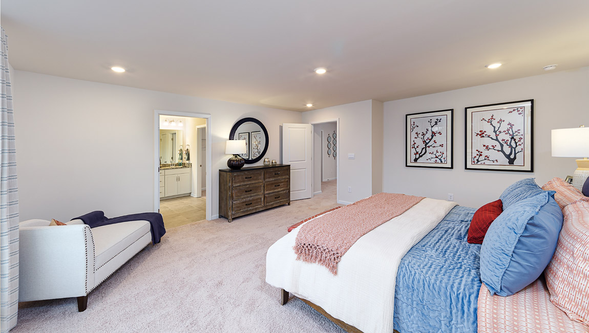 Primary bedroom carpeted with large window
