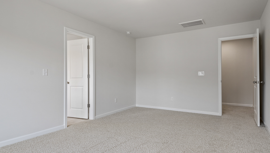Primary carpeted bedroom with large window