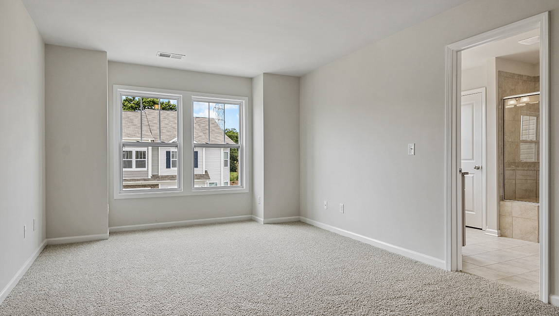 Primary carpeted bedroom with large window
