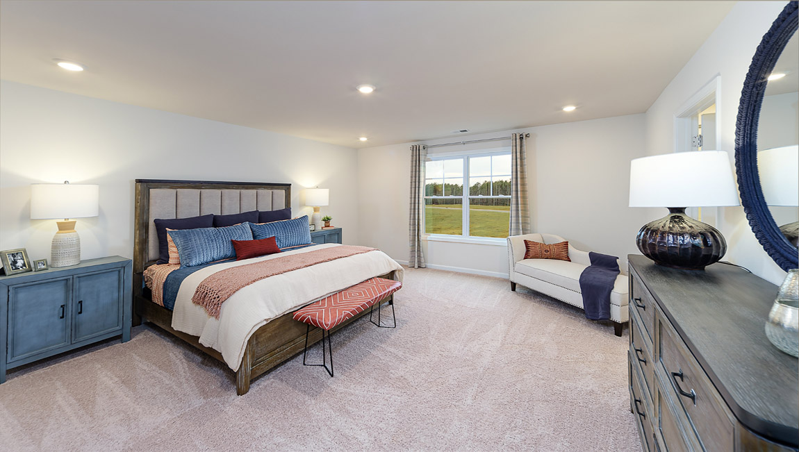 Primary carpeted bedroom with large windows