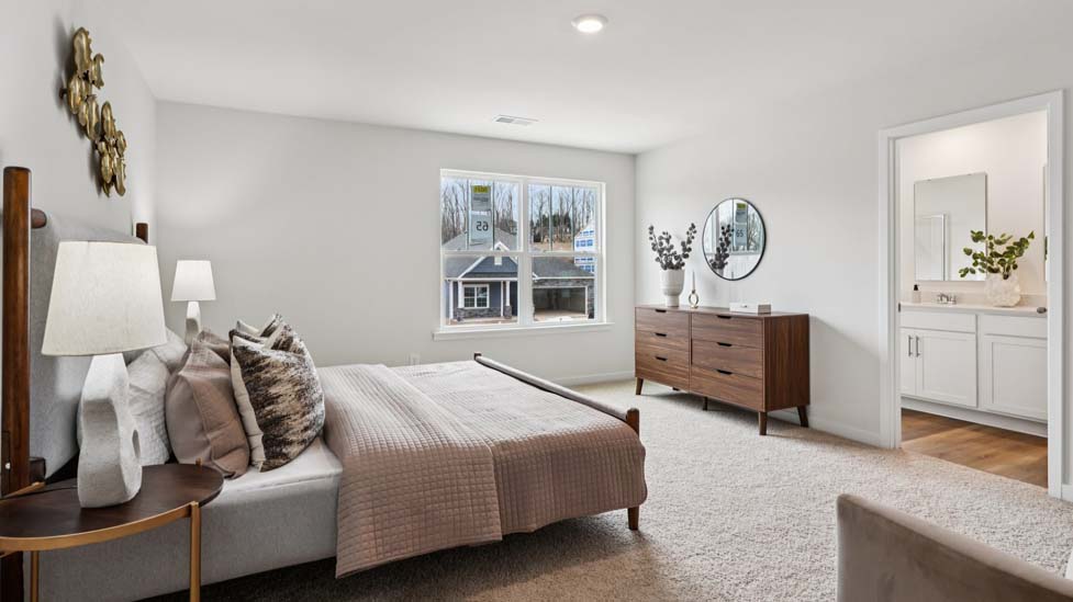Primary carpeted bedroom with large window