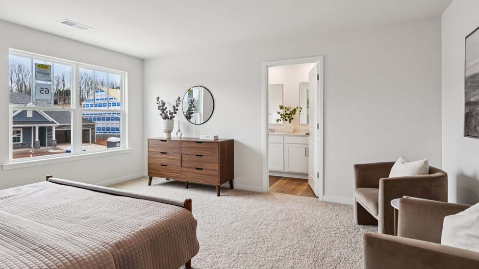 Primary carpeted bedroom with large window