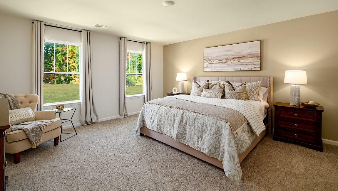 primary bedroom with carpet and large windows