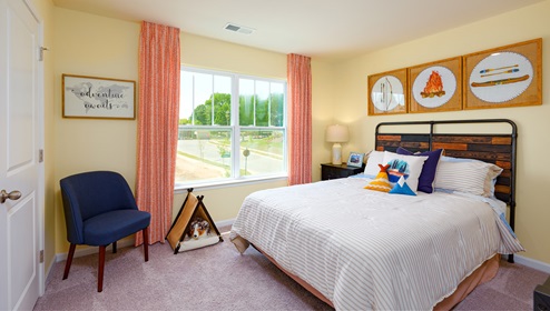 Model carpeted bedroom with large window