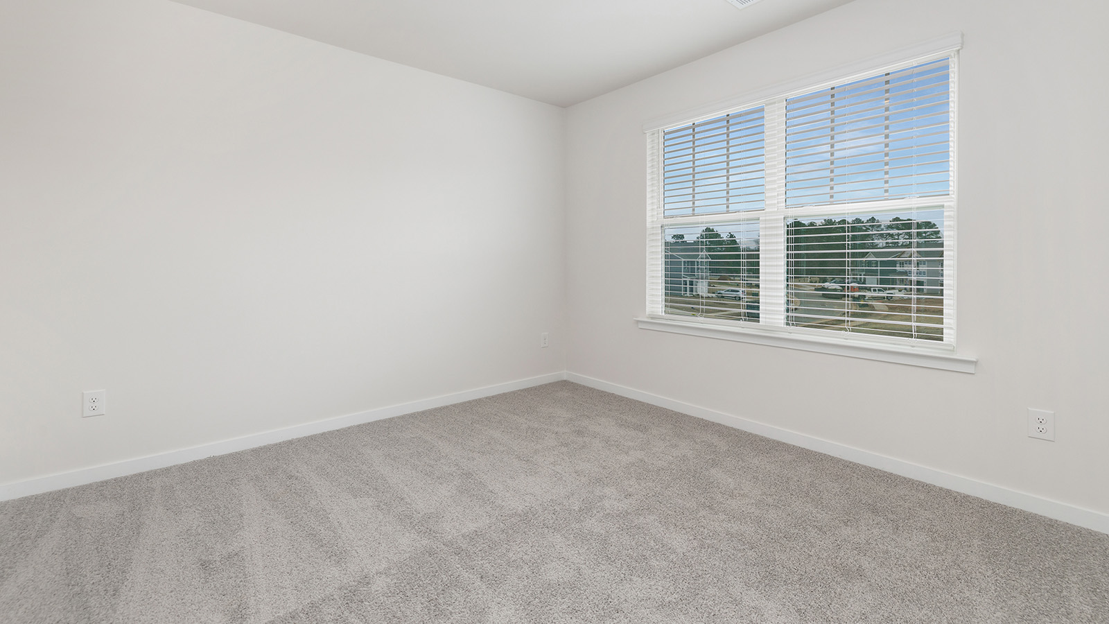 Model carpeted bedroom with small window