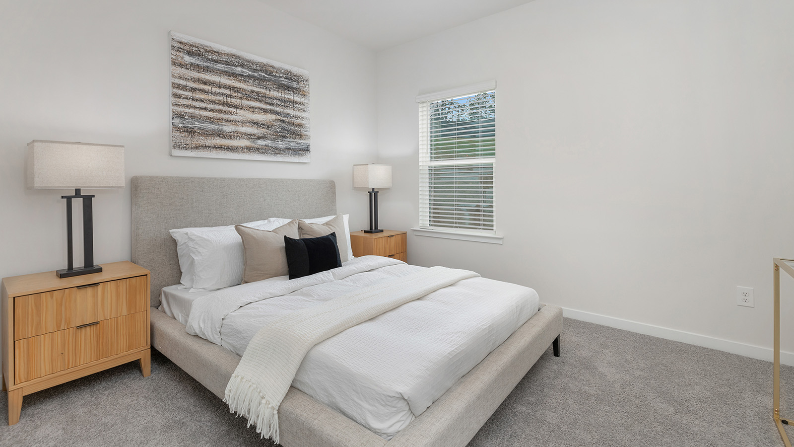 Model carpeted bedroom with small window