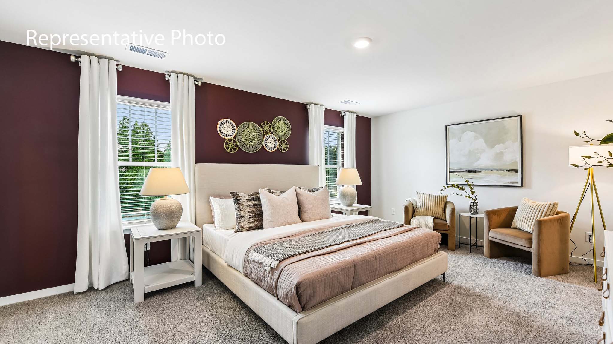 primary carpeted bedroom with windows