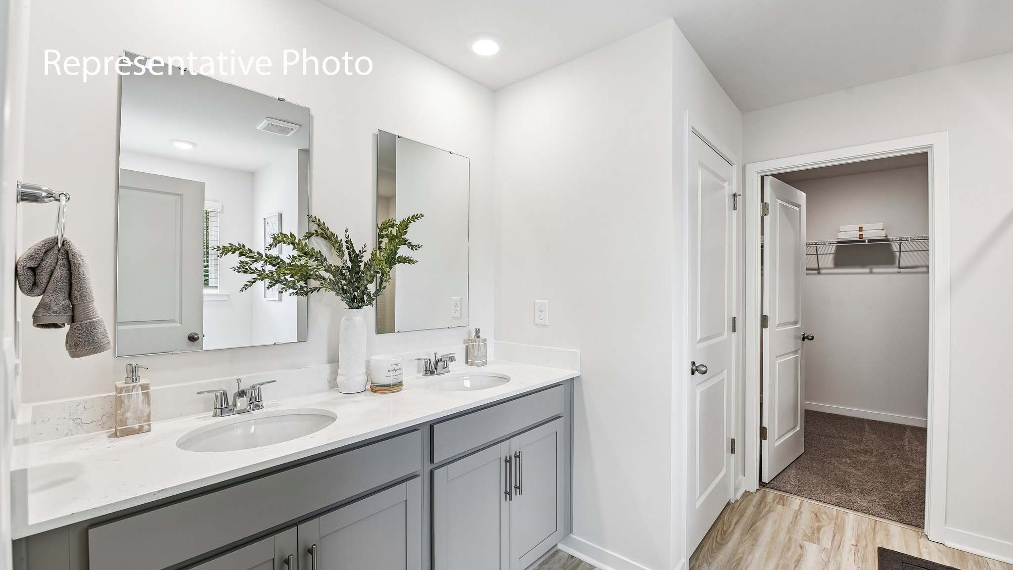 primary bathroom with double sinks and standing glass shower