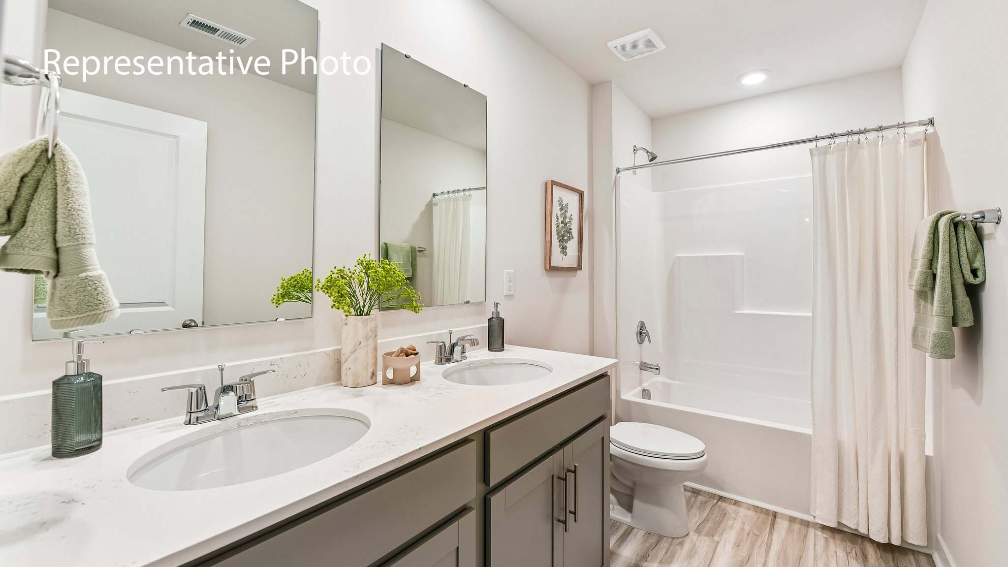 bathroom with double sinks and standing tub shower