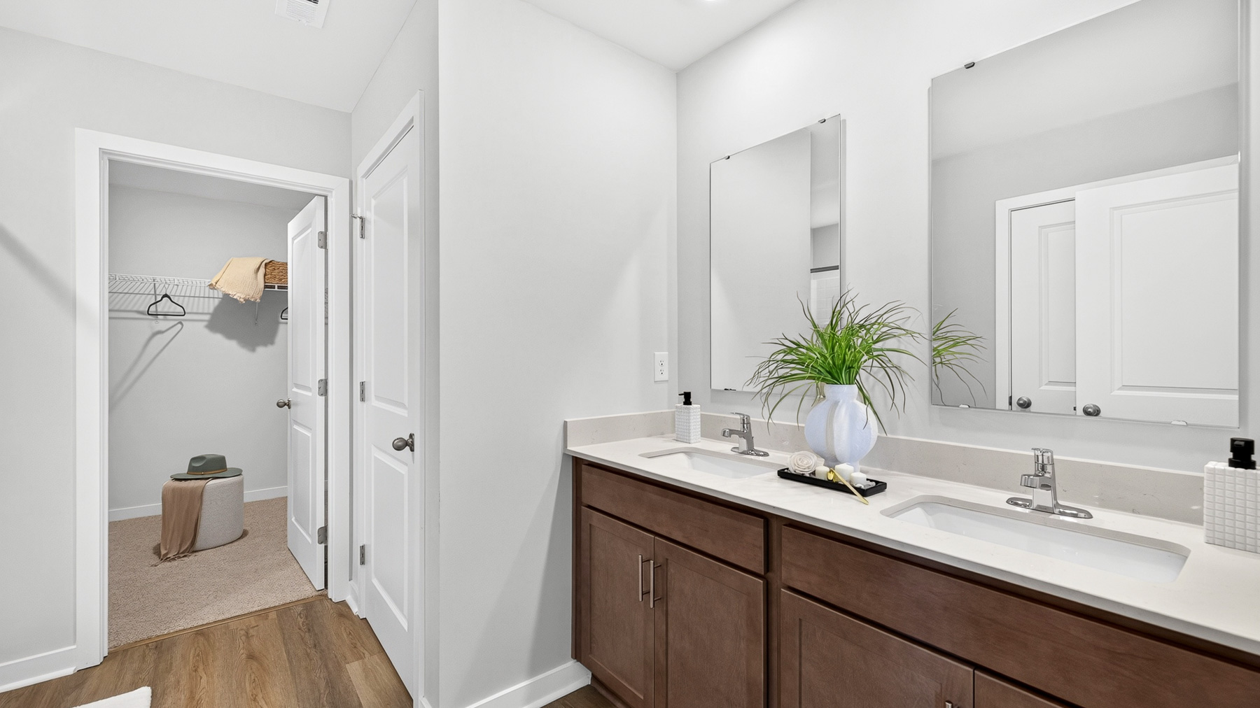Primary bathroom with brown cabinets and standing glass shower