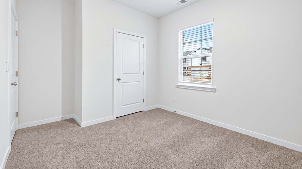 carpeted bedroom with large windows
