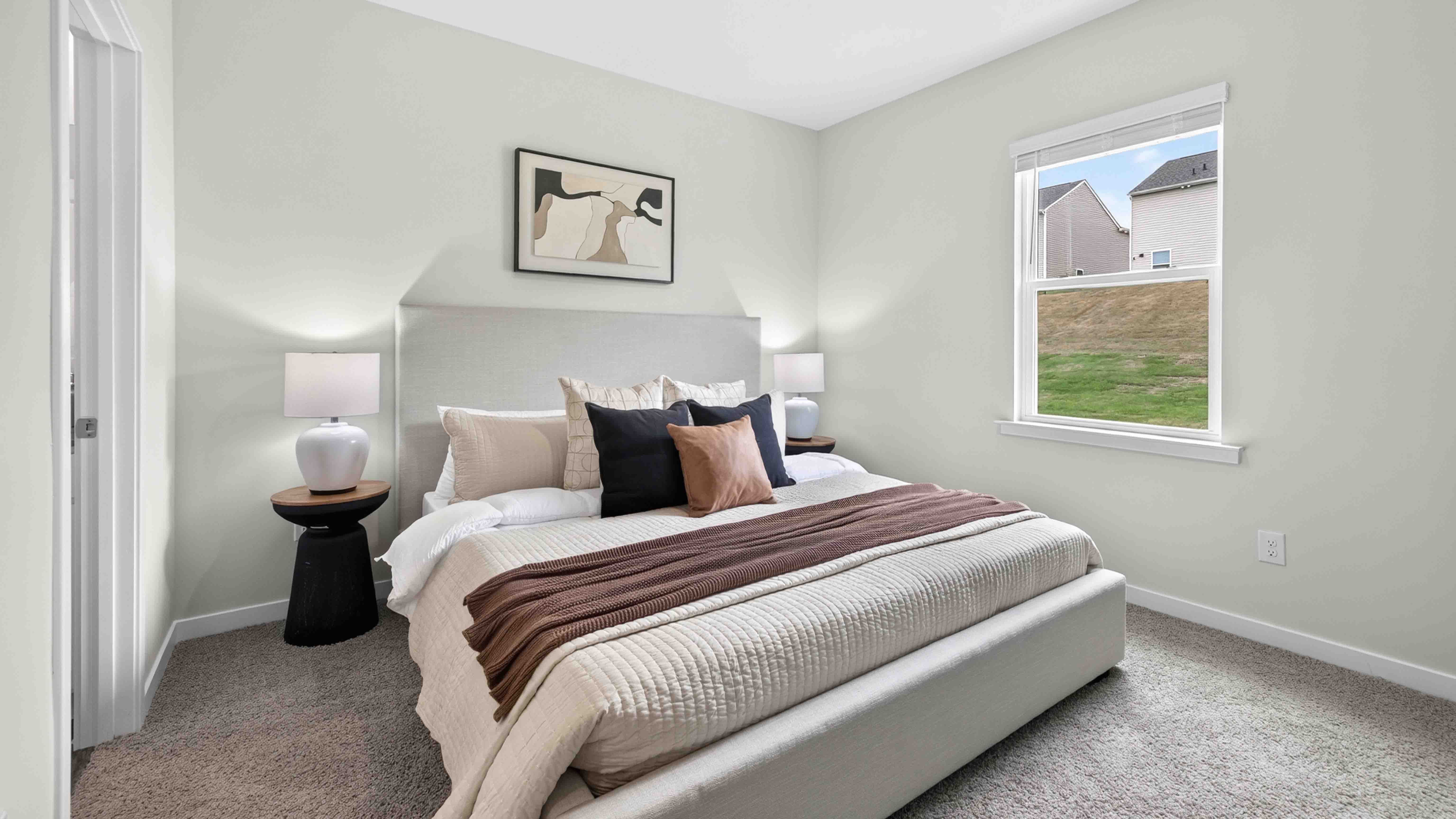 Primary carpeted bedroom with windows
