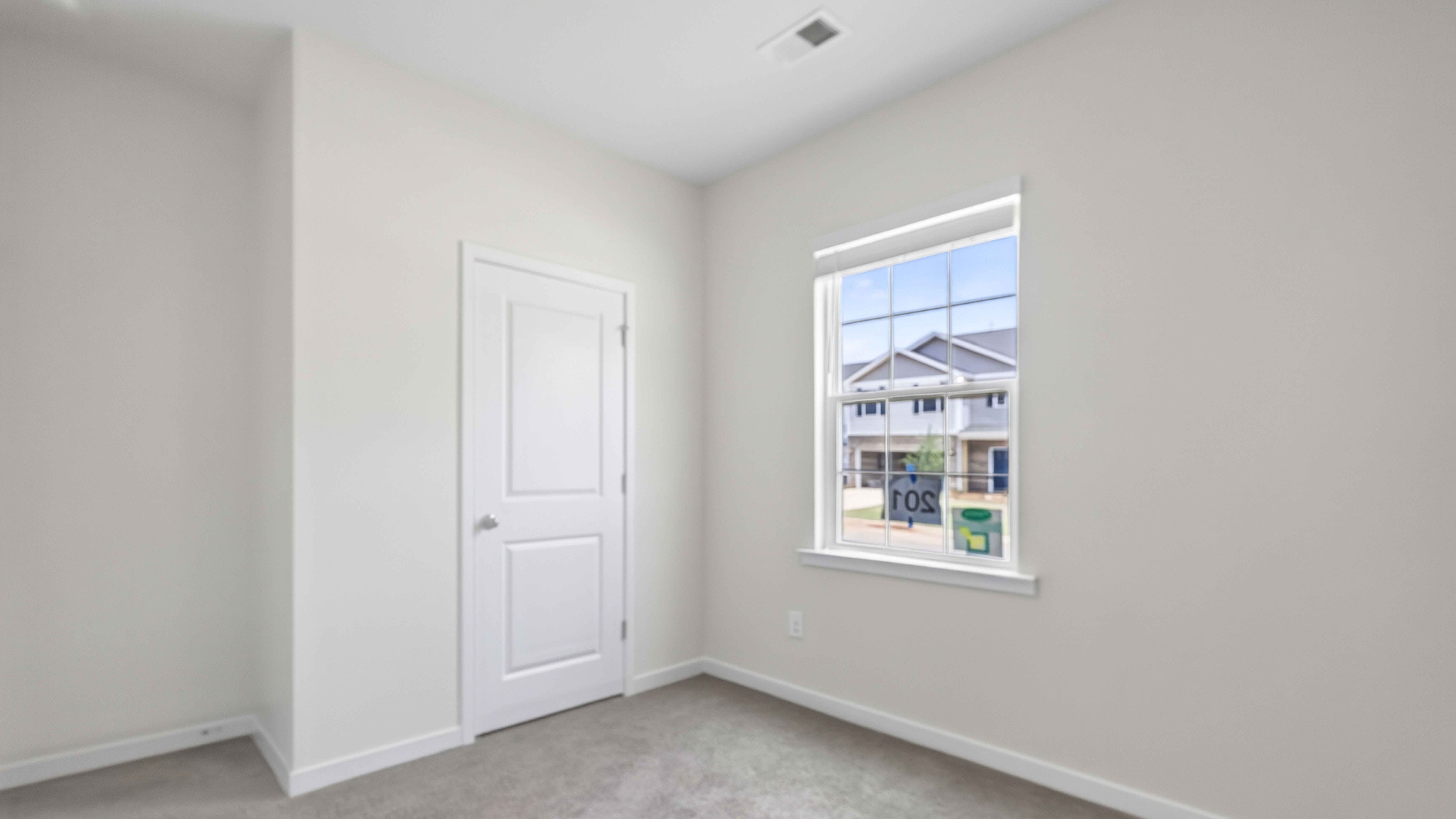 carpeted bedroom with large windows