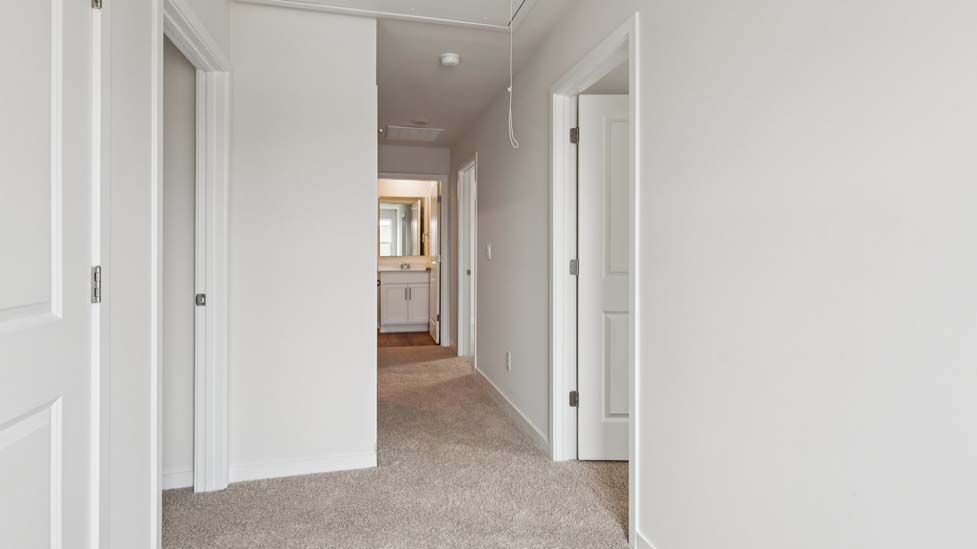 Carpeted bedroom with large window, view of bathroom door