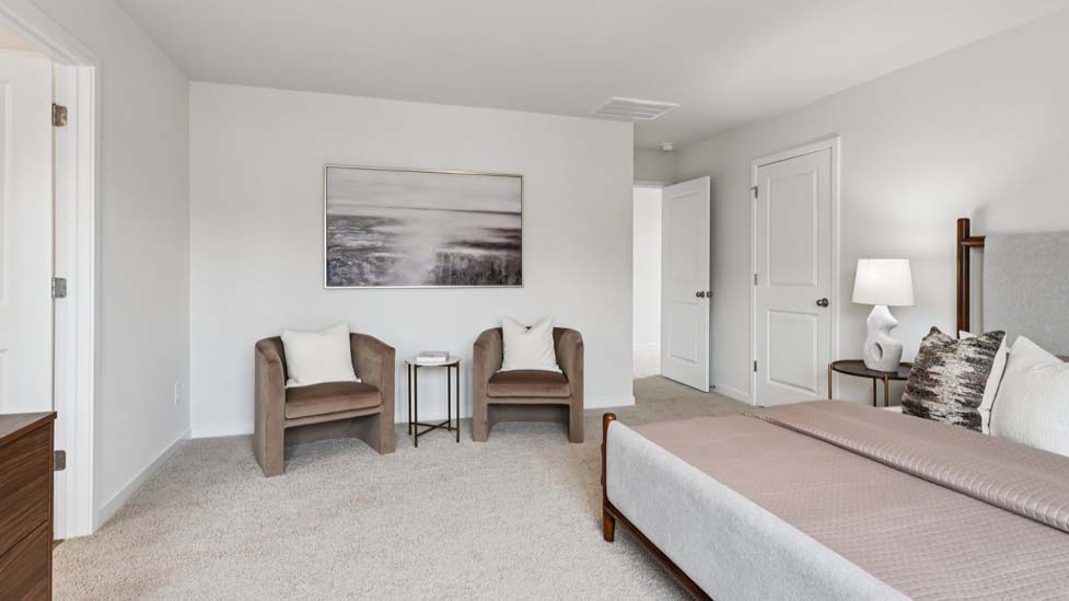 Carpeted bedroom with large window, view of bathroom door