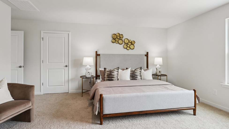 Carpeted bedroom with large window, view of bathroom door