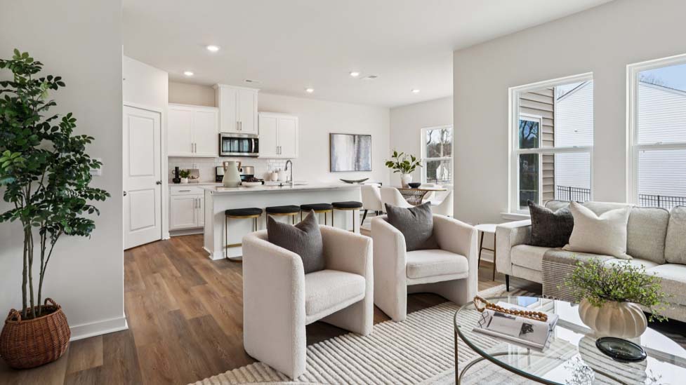 Living room space with wood floors, three large windows