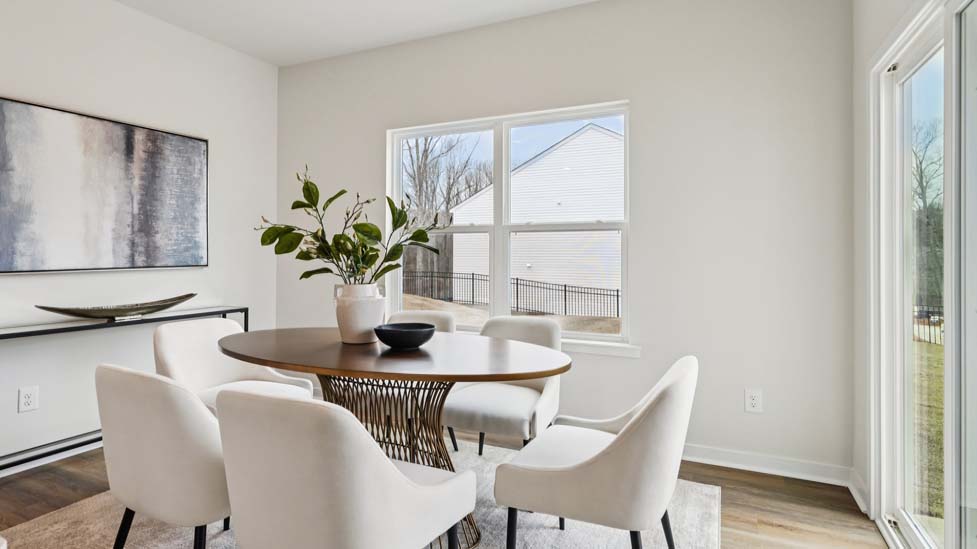 Breakfast area with wood floors, large window, and sliding glass back door