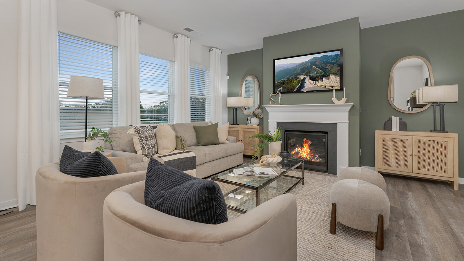 Living room space with wood floors, three large windows