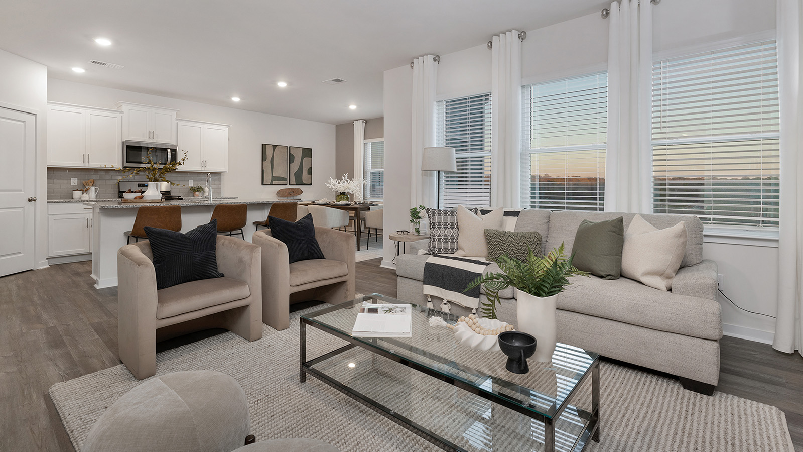 Living room space with wood floors, three large windows