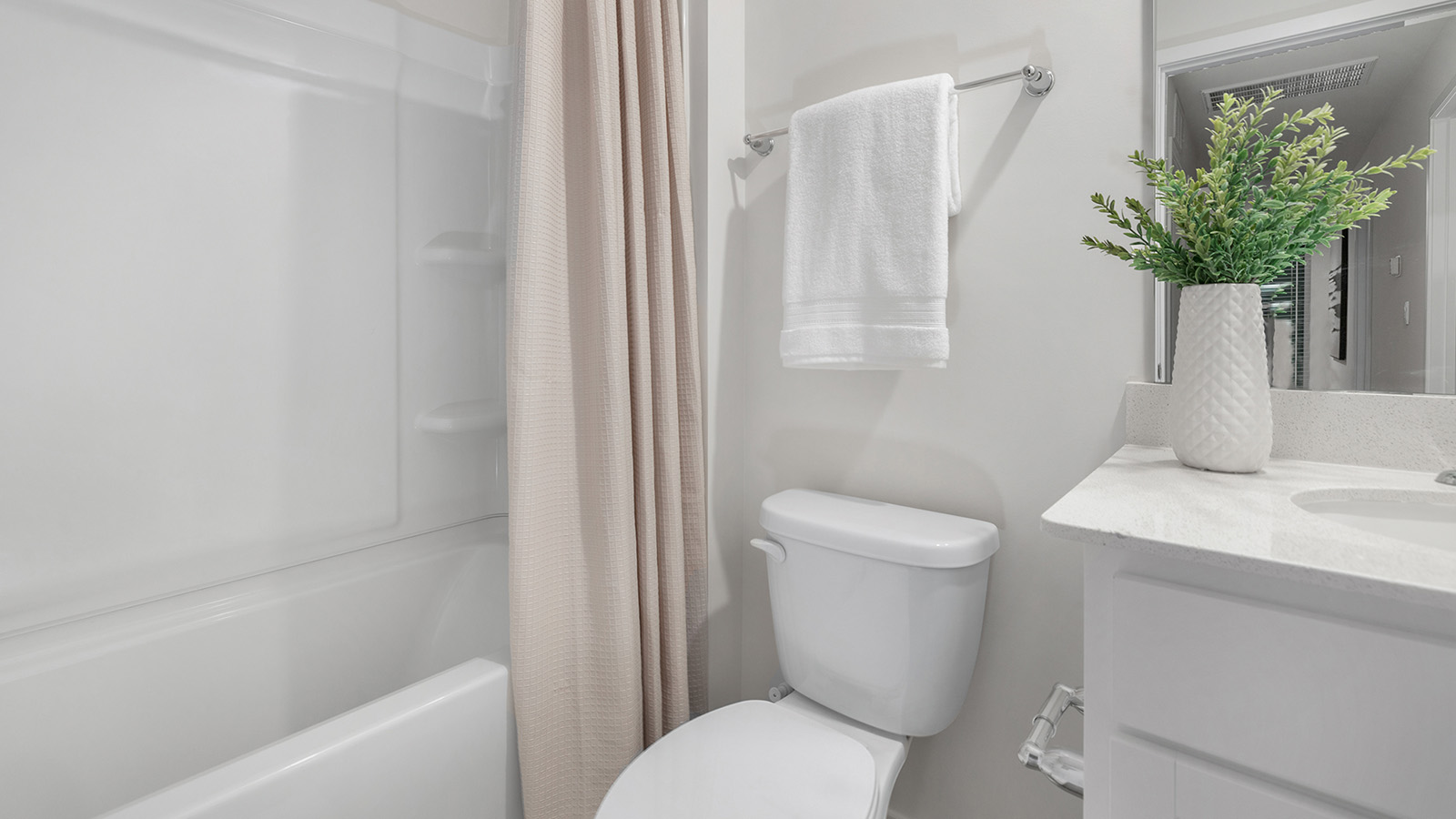 Secondary bathroom with white cabinets and countertop and shower and bathtub combination