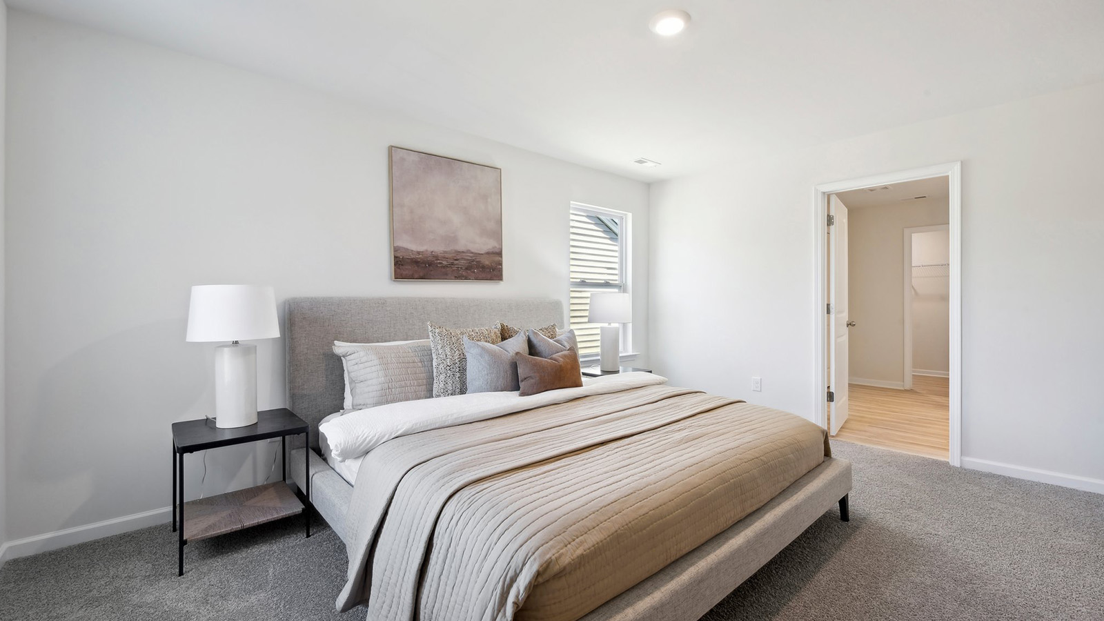 primary carpeted bedroom with windows