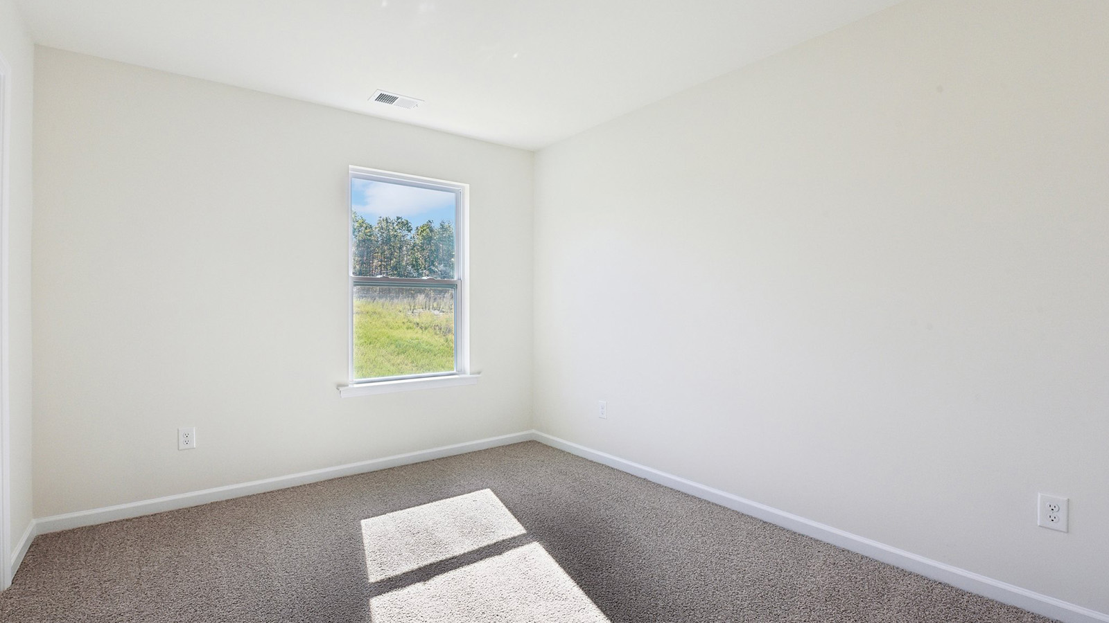 Carpeted bedroom with windows