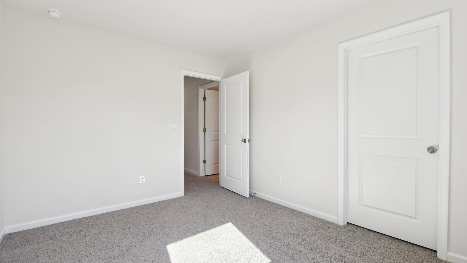 Carpeted bedroom with windows
