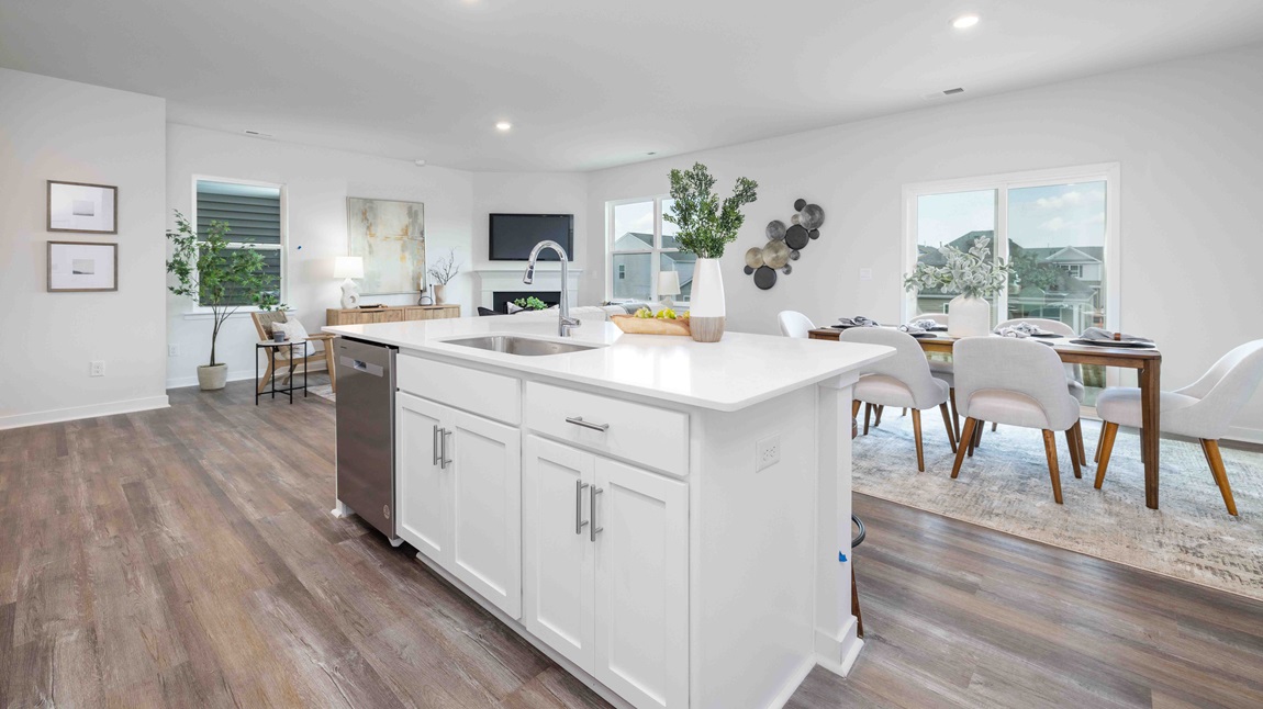 Kitchen and island, white cabinets, wood floors, and stainless steel appliances