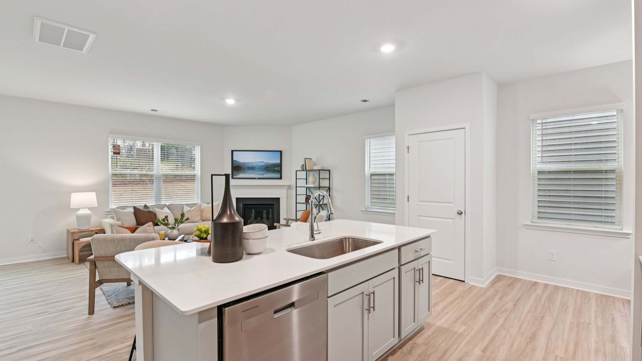 Kitchen and island with white cabinets, white subway tile backsplash and stainless steel appliances