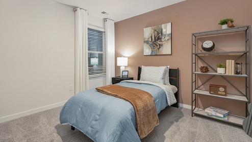 Secondary carpeted bedroom with small window