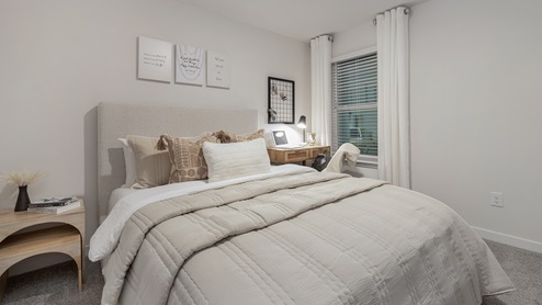 Secondary carpeted bedroom with small window